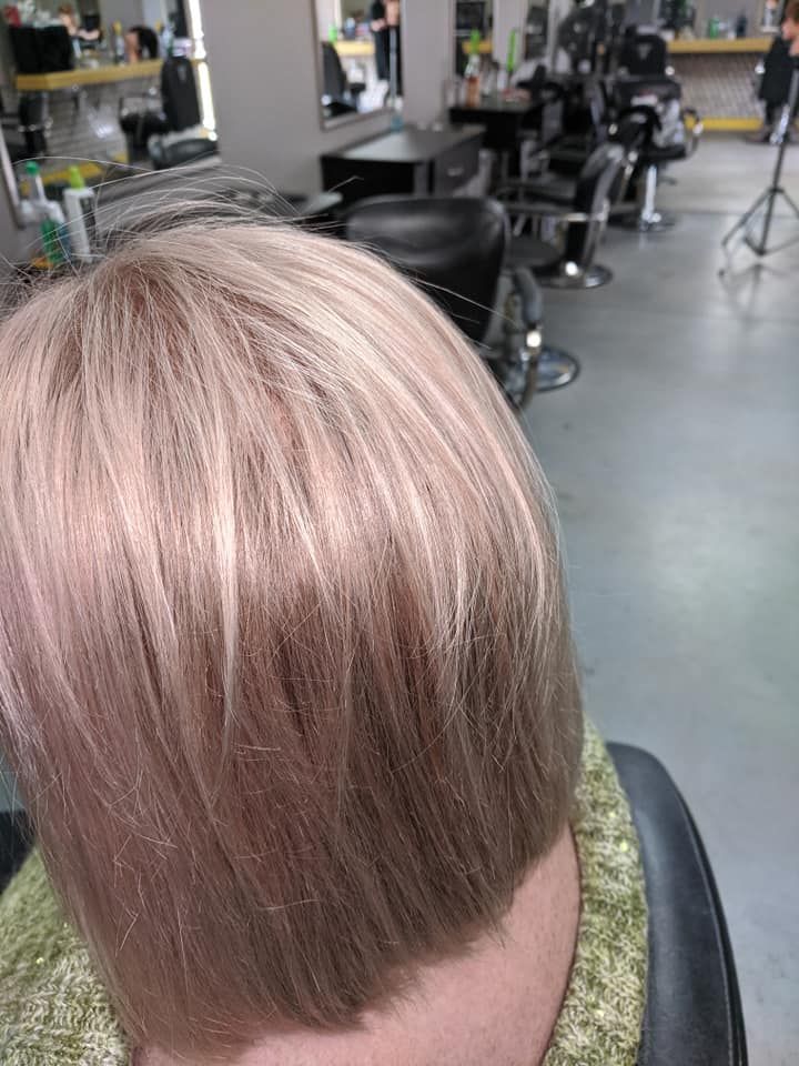 Short blond haircut with a blunt fringe in a salon chair