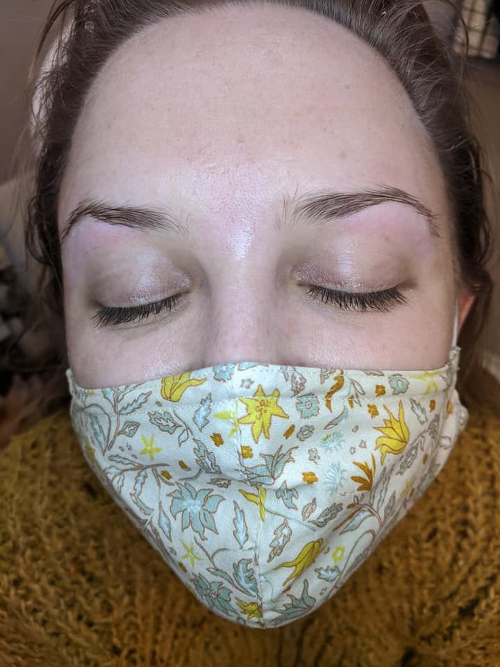 Close-up of a person wearing a floral face mask, eyes closed.