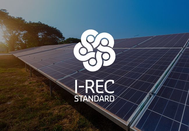 Logotipo da norma I-REC sobre painéis solares ao pôr do sol.