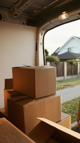 Boxes stacked inside a cargo van, open to a suburban street.