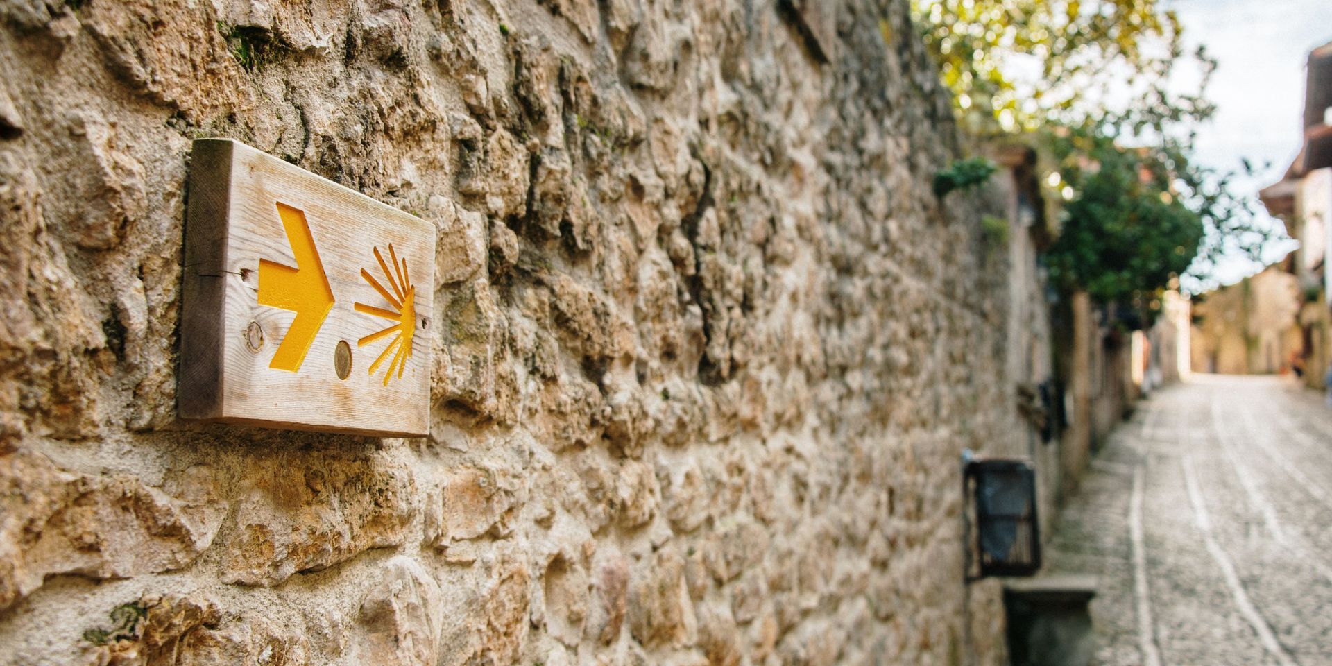 Camino de Santiago Pilgrimage Typical Road Signs on a Rock Wall - Blog Post Barters Travelnet