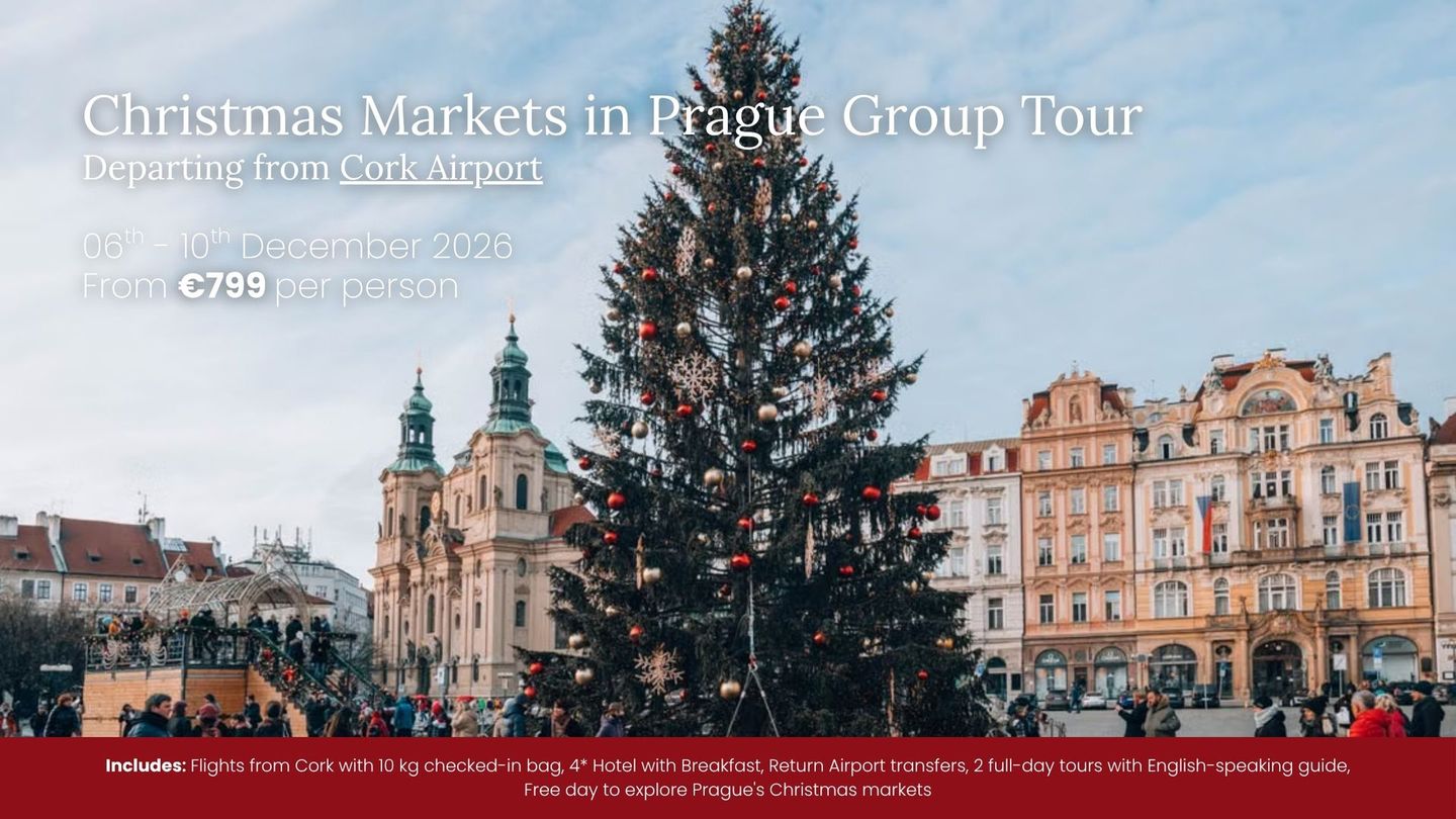Christmas market in Prague with a large decorated tree in Old Town Square and historic buildings behind it