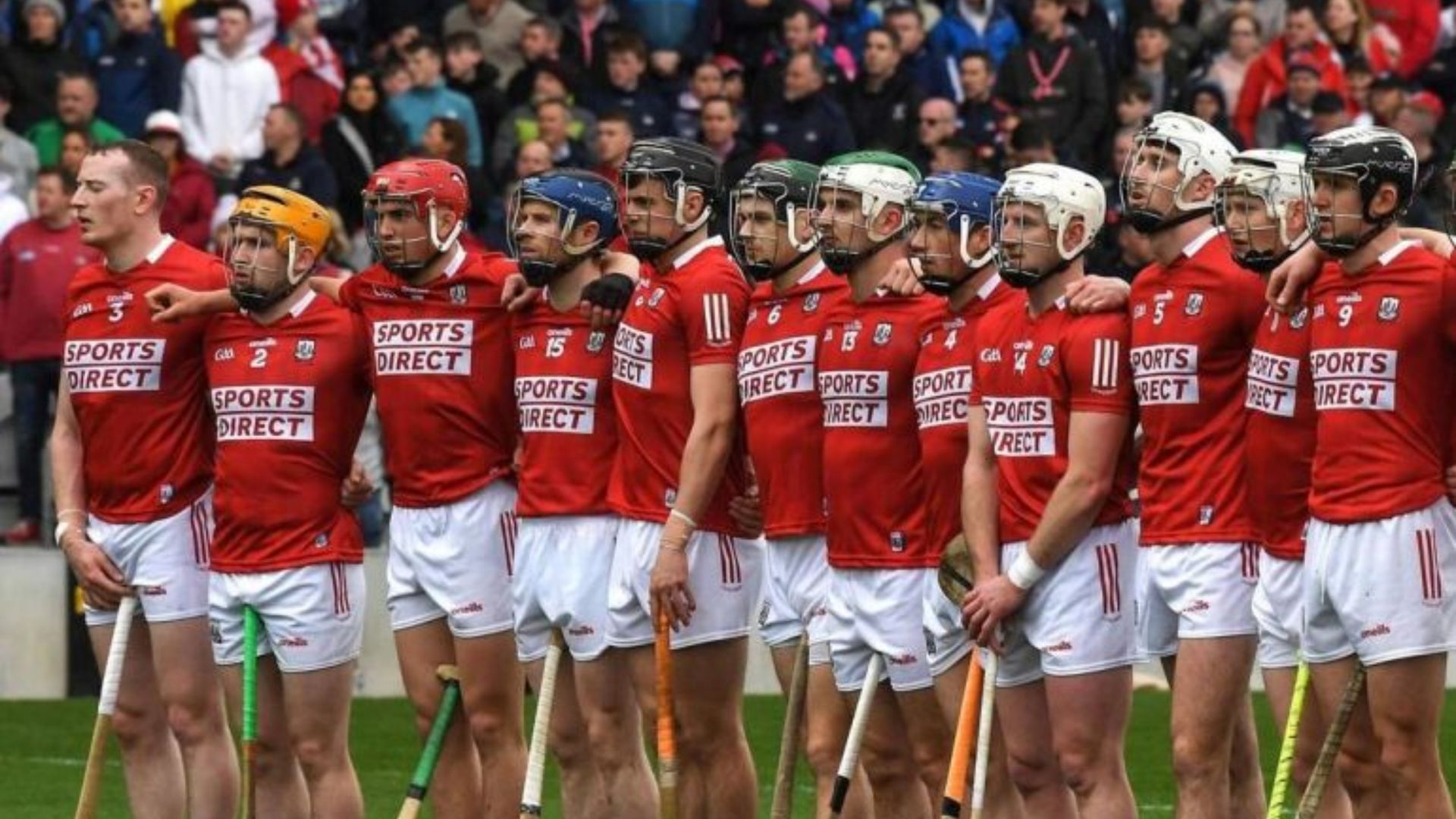 Cork Hurling team in red jerseys standing in a line on the field before a match