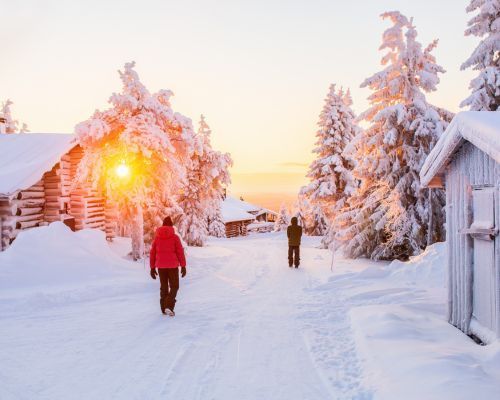 A couple of people are walking down a snowy road.