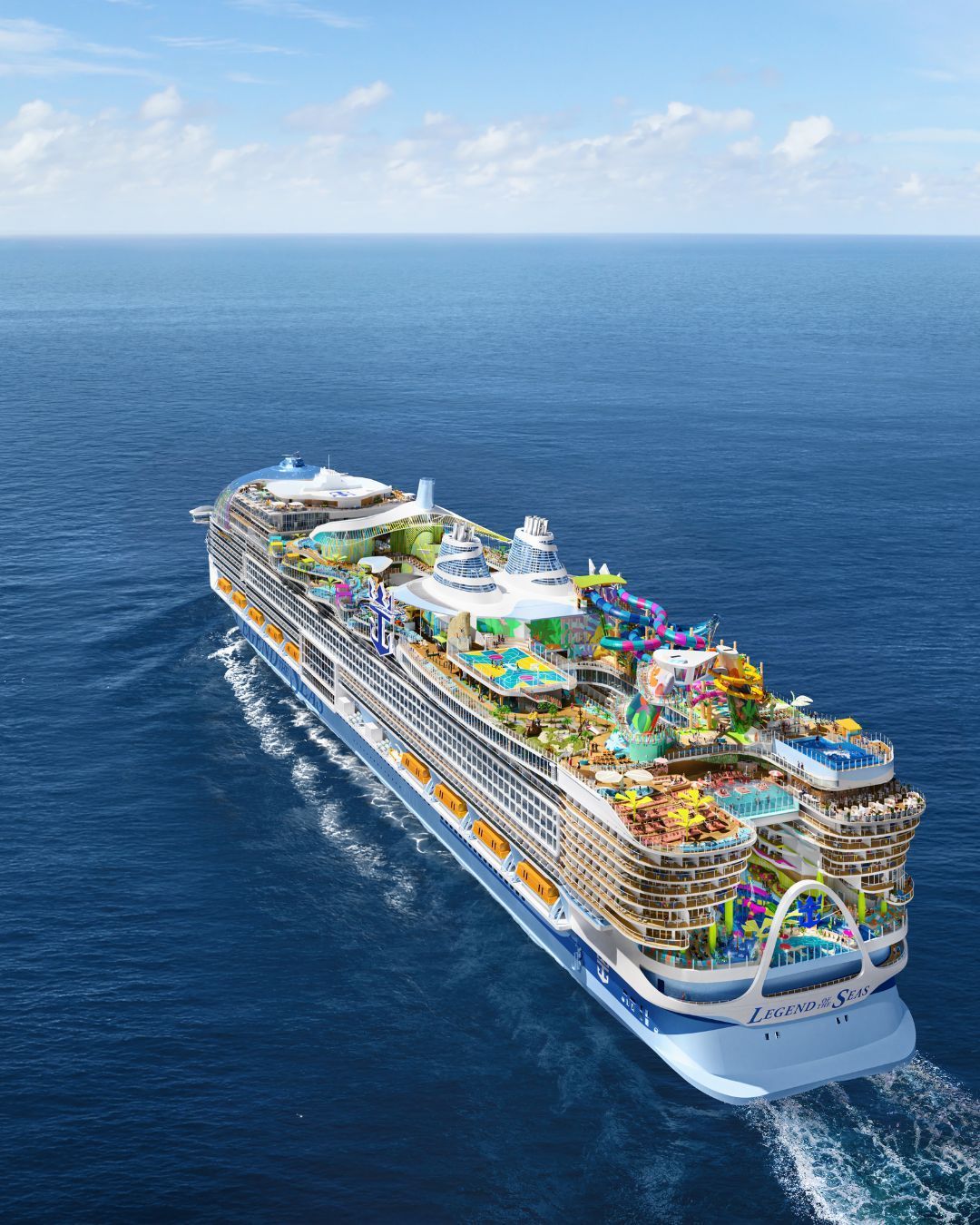Large cruise ship with colorful water slides sailing on a calm blue ocean under a bright sky