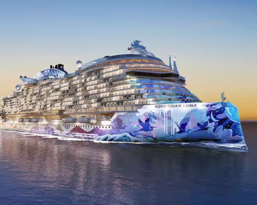 Norwegian Cruise Luna with a colorful floral bow sailing on calm water at sunset