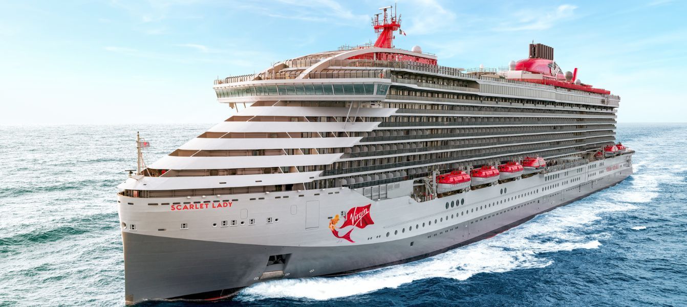 Scarlet Lady cruise ship from Virgin Voyages sailing on open water, with red accents and a red funnel.