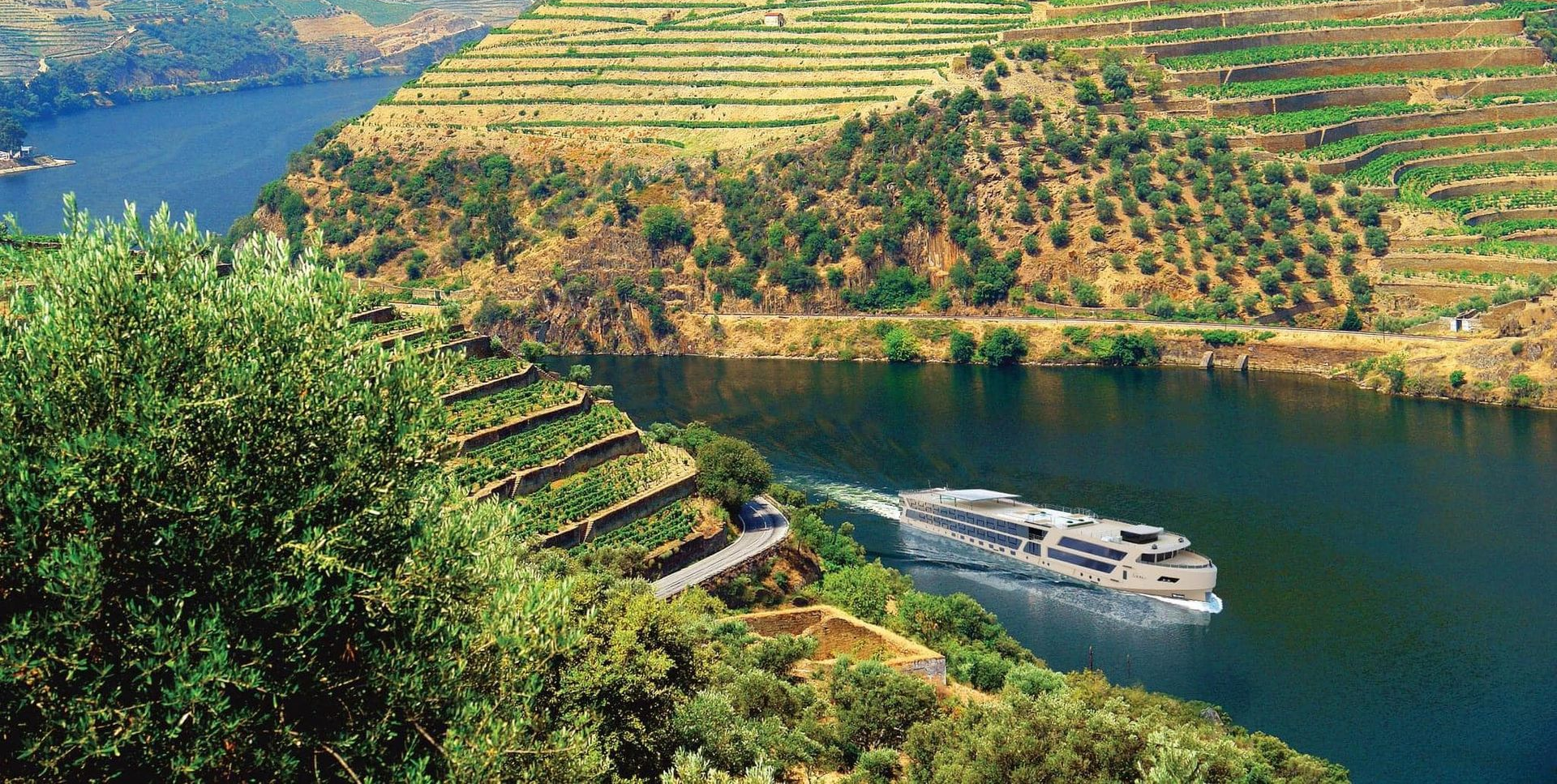 Travelmarvel river cruise ship on a blue lake beside terraced green vineyards and a hillside village in the Douro Valley, Portugal