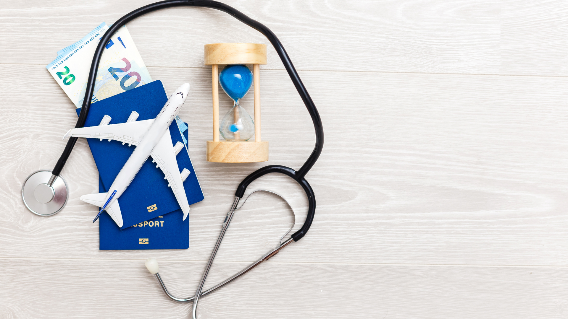 a stethoscope , airplane , money , and an hourglass are on a wooden table . Barter's Travelnet 