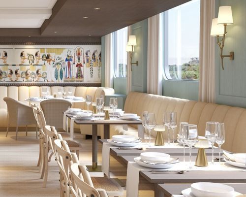 Travelmarvel Sirius River cruise ship,elegant restaurant dining room with cream banquettes, set tables, wall art, and large windows overlooking greenery