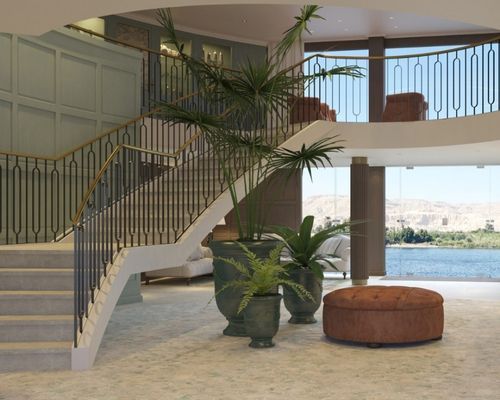 Travelmarvel Sirius river cruise ship, spacious lobby with curved staircase, indoor palm plants, and a large window overlooking water.