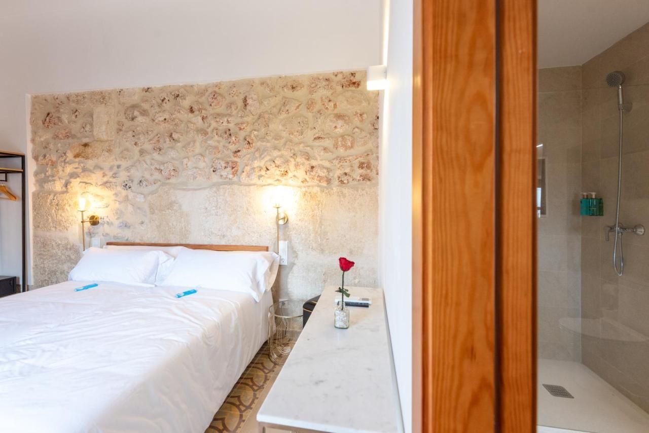 Un dormitorio con una cama grande y una ducha a ras de suelo.
