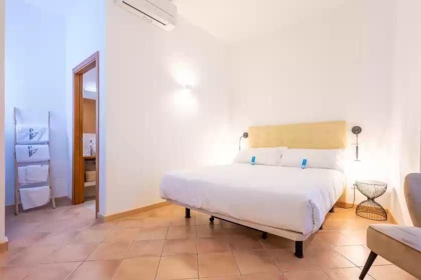 Un dormitorio con dos camas, una silla y una ventana.