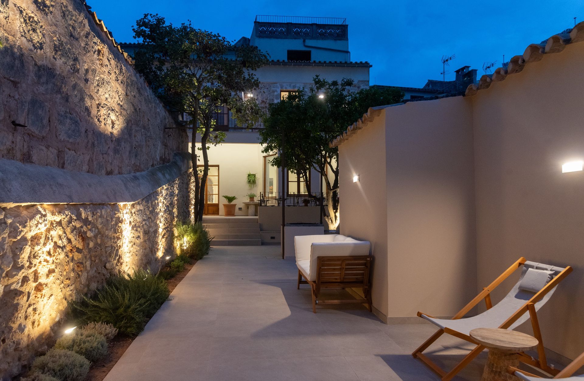 Un patio con sillas y un sofá frente a un edificio.