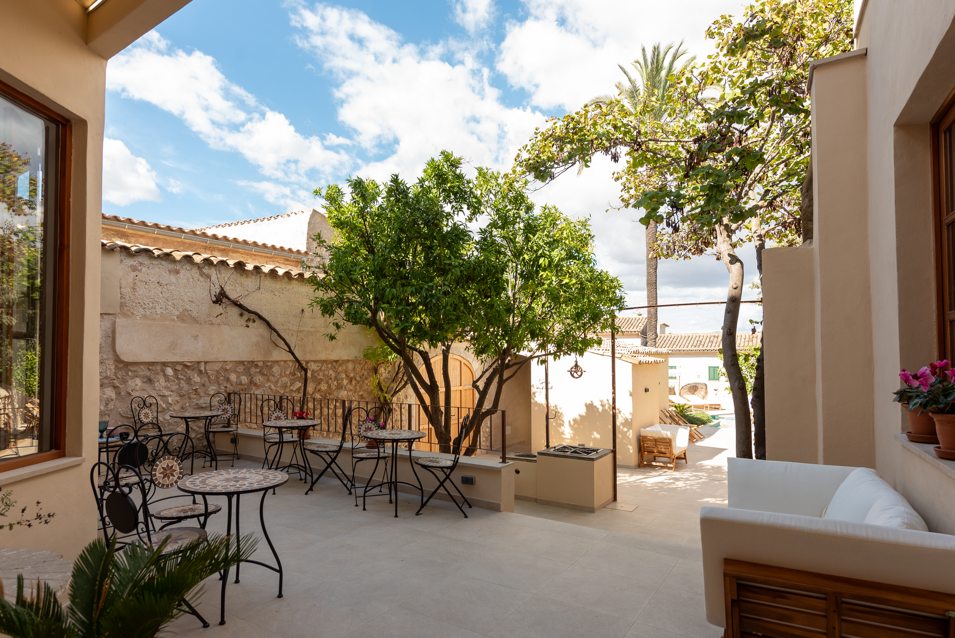 Un patio con mesas y sillas frente a un edificio.