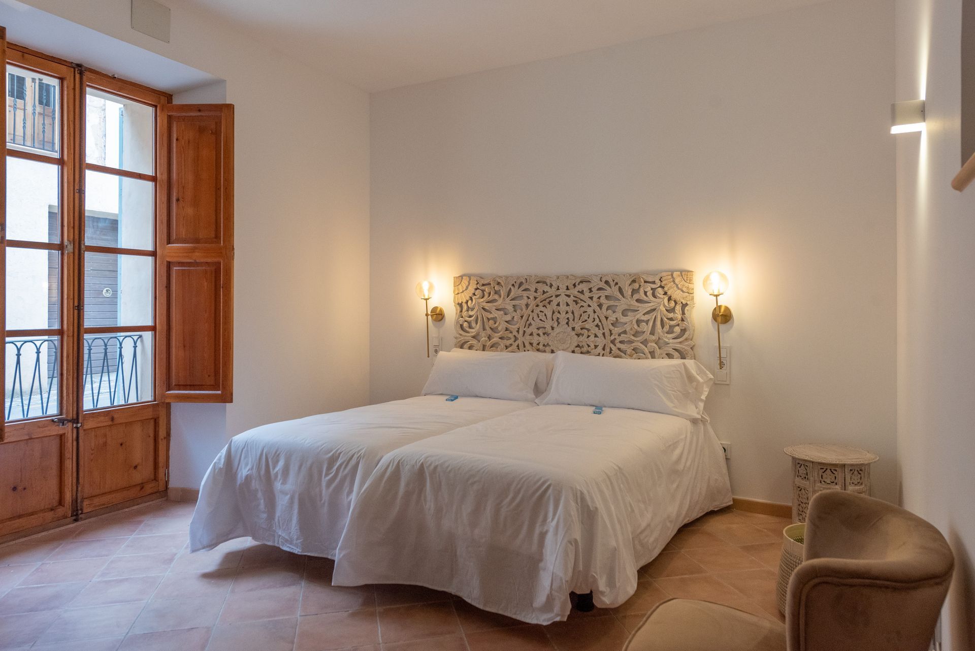 Un dormitorio con dos camas, una silla y una ventana.