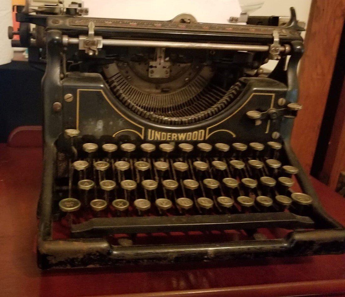 An old underwood typewriter sits on a table.