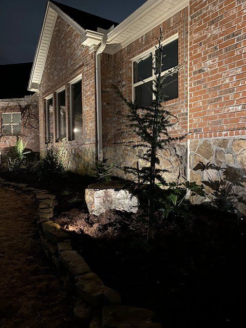 A brick house with lights on the side of it at night.