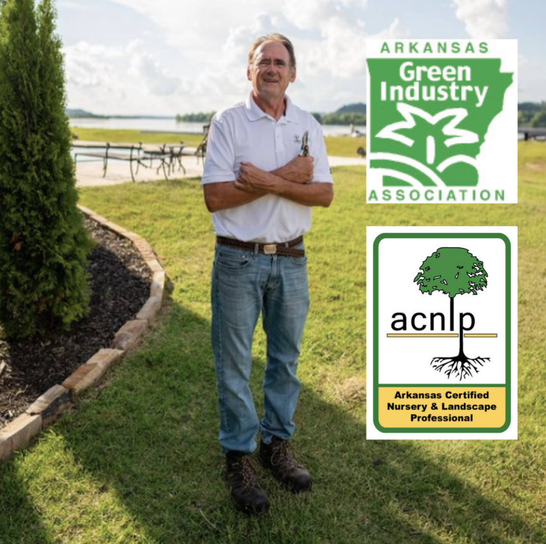 A man standing in a grassy field with arkansas green industry association logos
