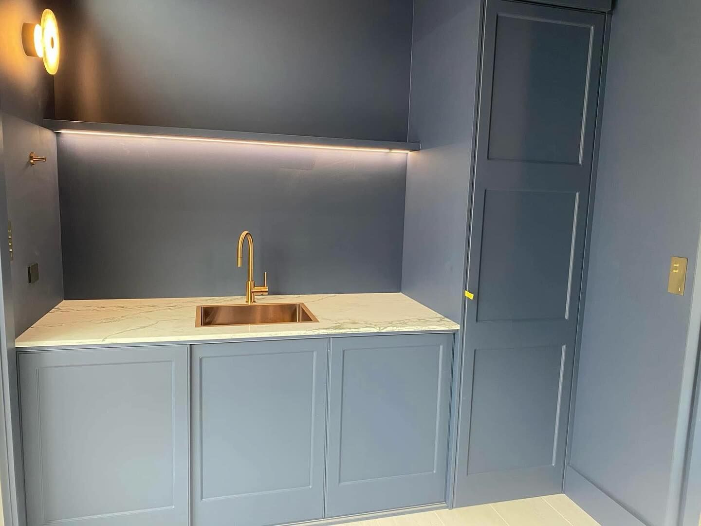 A kitchen with a sink, cabinets and a door — Coastal Detail Joinery in Tuncurry, NSW