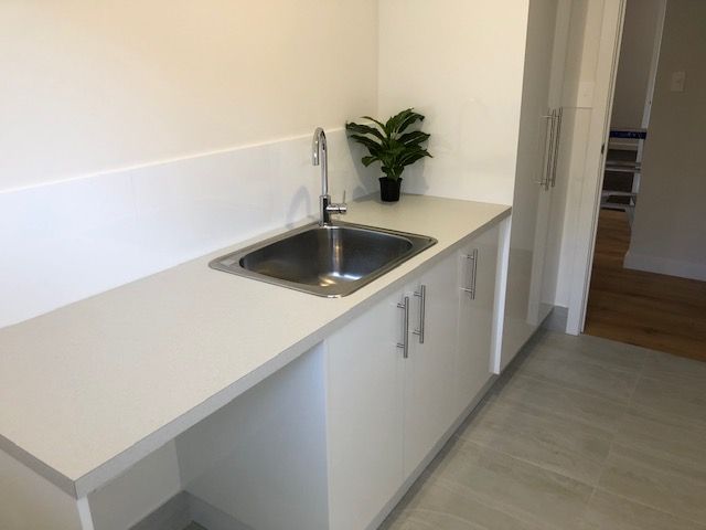 A Kitchen With a Sink and a Plant on the Counter — Coastal Detail Joinery in Tuncurry, NSW