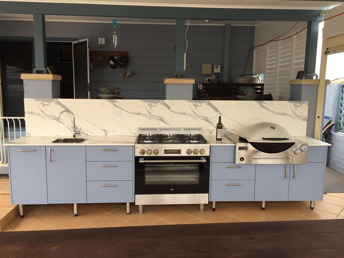 A Kitchen With Blue Cabinets and a Stove and Oven — Coastal Detail Joinery in Tuncurry, NSW