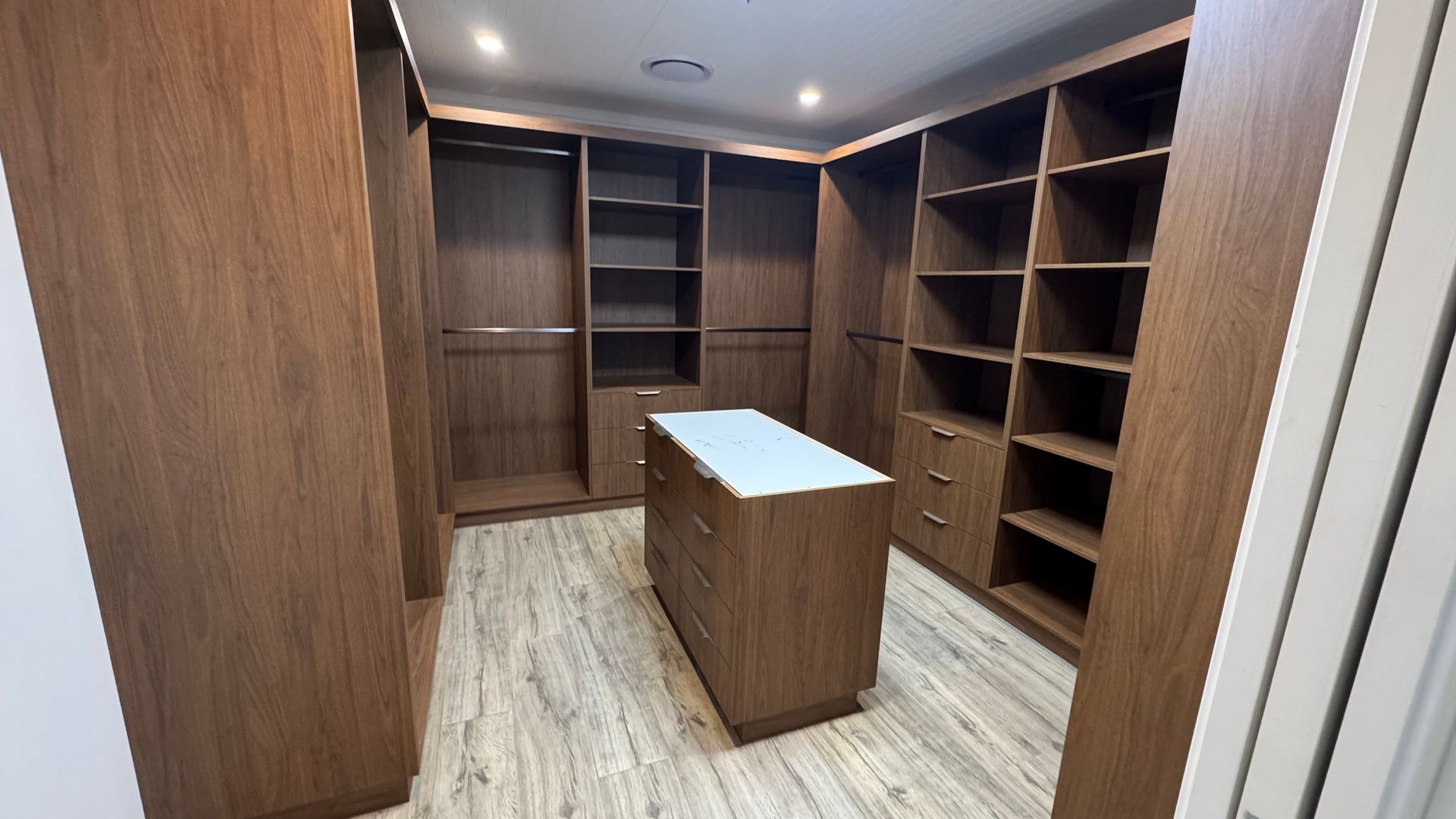 A walk in closet with lots of wooden shelves and drawers — Coastal Detail Joinery in Tuncurry, NSW
