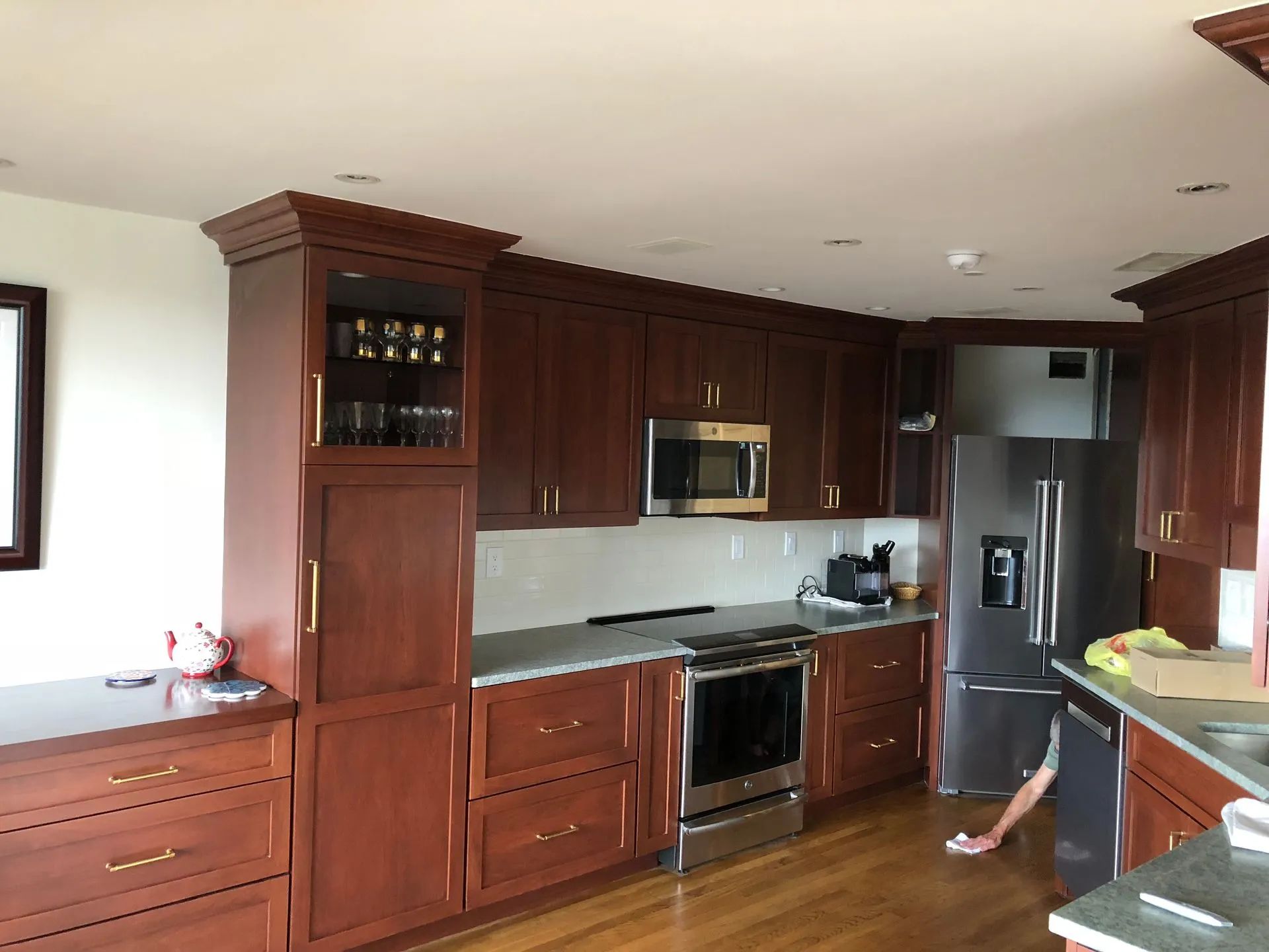 Kitchen with dark wood cabinets, stainless steel appliances, and a light-colored countertop.
