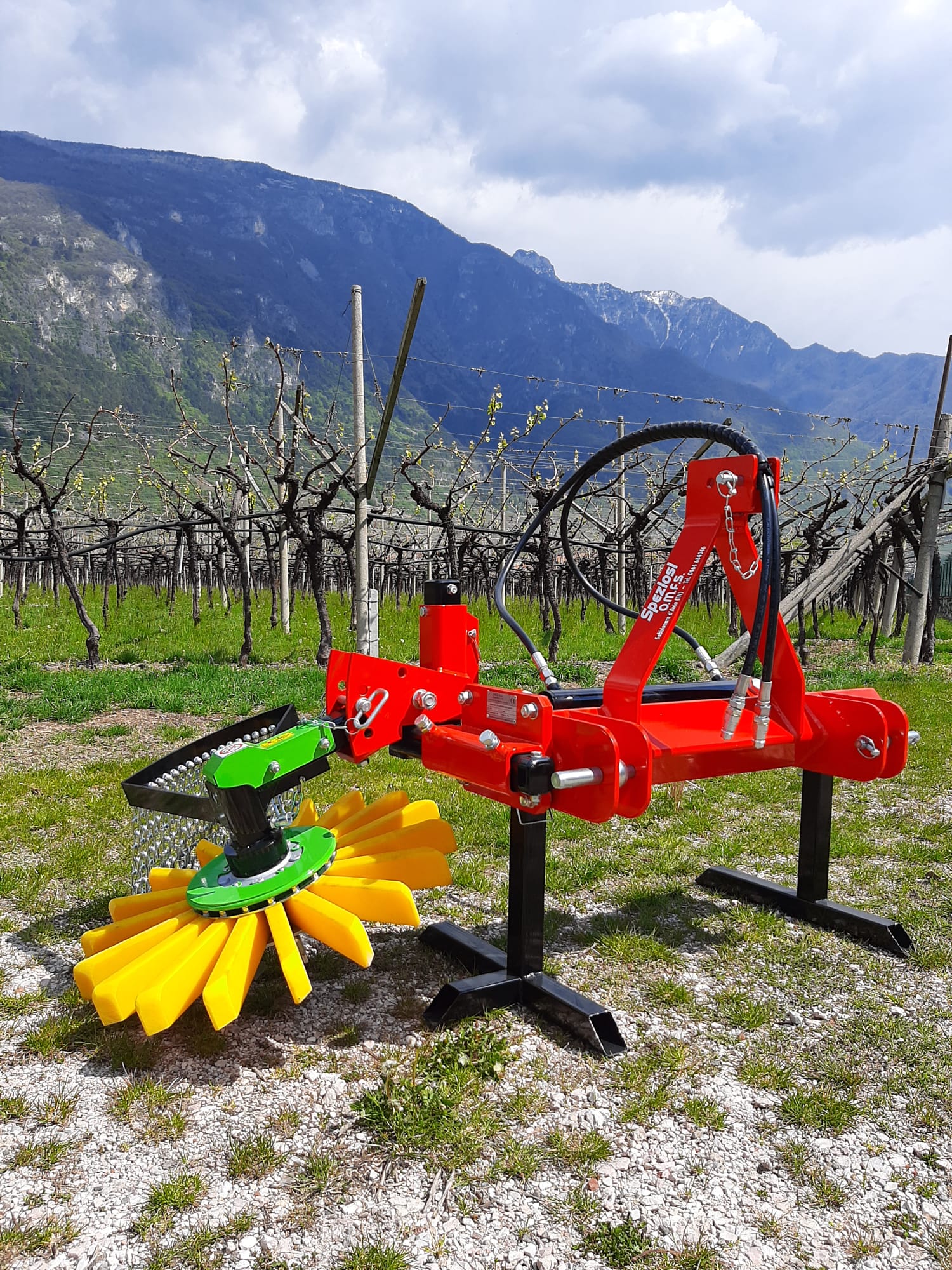 Due trattori sono parcheggiati in un campo con le montagne sullo sfondo.