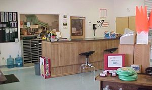 a large room with a wooden counter and stools .