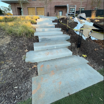 Metro Atlanta commercial concrete contractor builds hardscaped concrete step walkway down hillside behind retail space connecting to community park