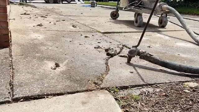 Cement driveway repair with patched and resealed asphalt, completed in Atlanta