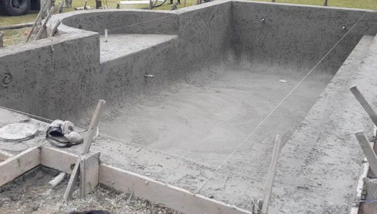 Metro Atlanta concrete pool builder pours fresh gunite concrete inside newly excavated in-ground pool installation