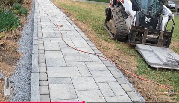 Metro Atlanta paver installer lays mixed-texture cut stone walkway with varied colors, directions, and small block border edging