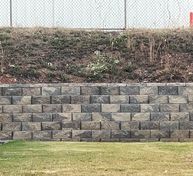Metro Atlanta retaining wall contractor builds stone retaining wall separating townhouse subdivision from self-storage property on hillside