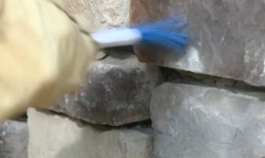 Metro Atlanta stone mason hand-brushing stonework during professional stone masonry installation.