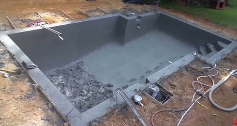 Metro Atlanta concrete pool builder pours gunite into newly excavated in-ground pool
