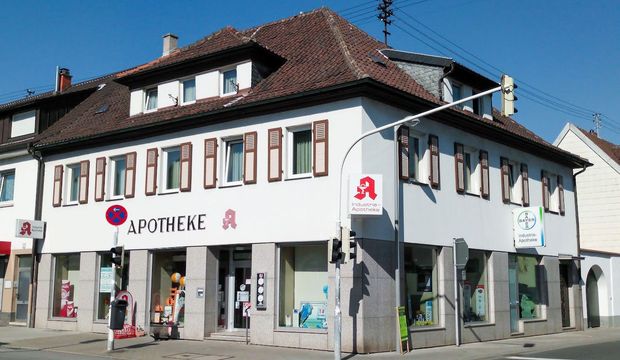 Ein weißes Gebäude mit einem Schild mit der Aufschrift „Apotheke“ darauf