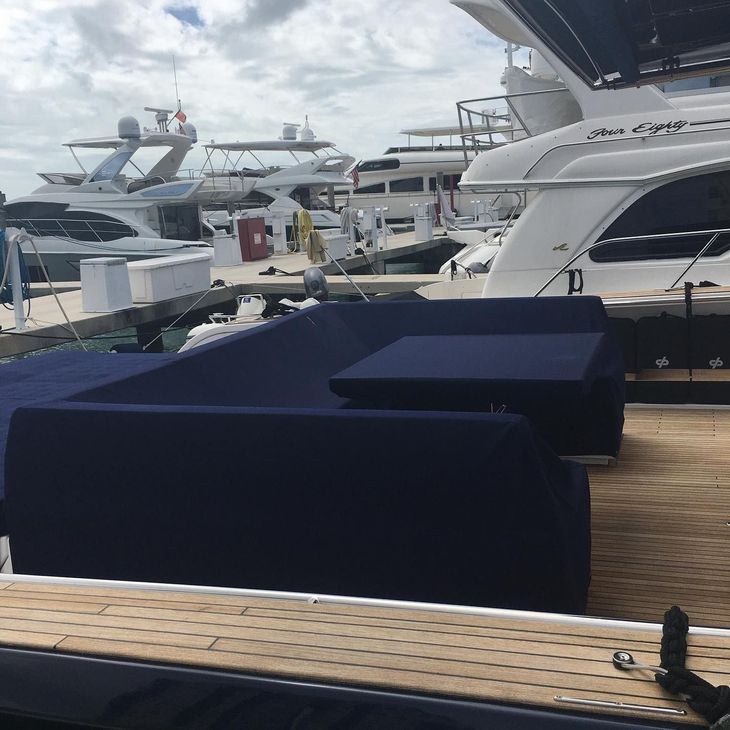A row of boats are docked at a marina