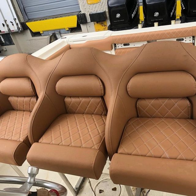 A row of brown leather seats on a boat.