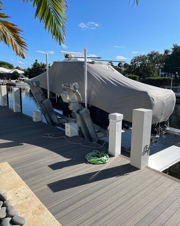 A boat is sitting on a dock with a cover on it.