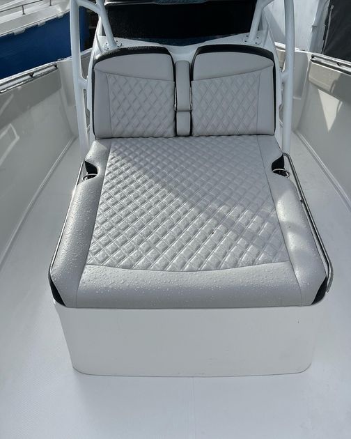 A white boat with two seats on the front of it