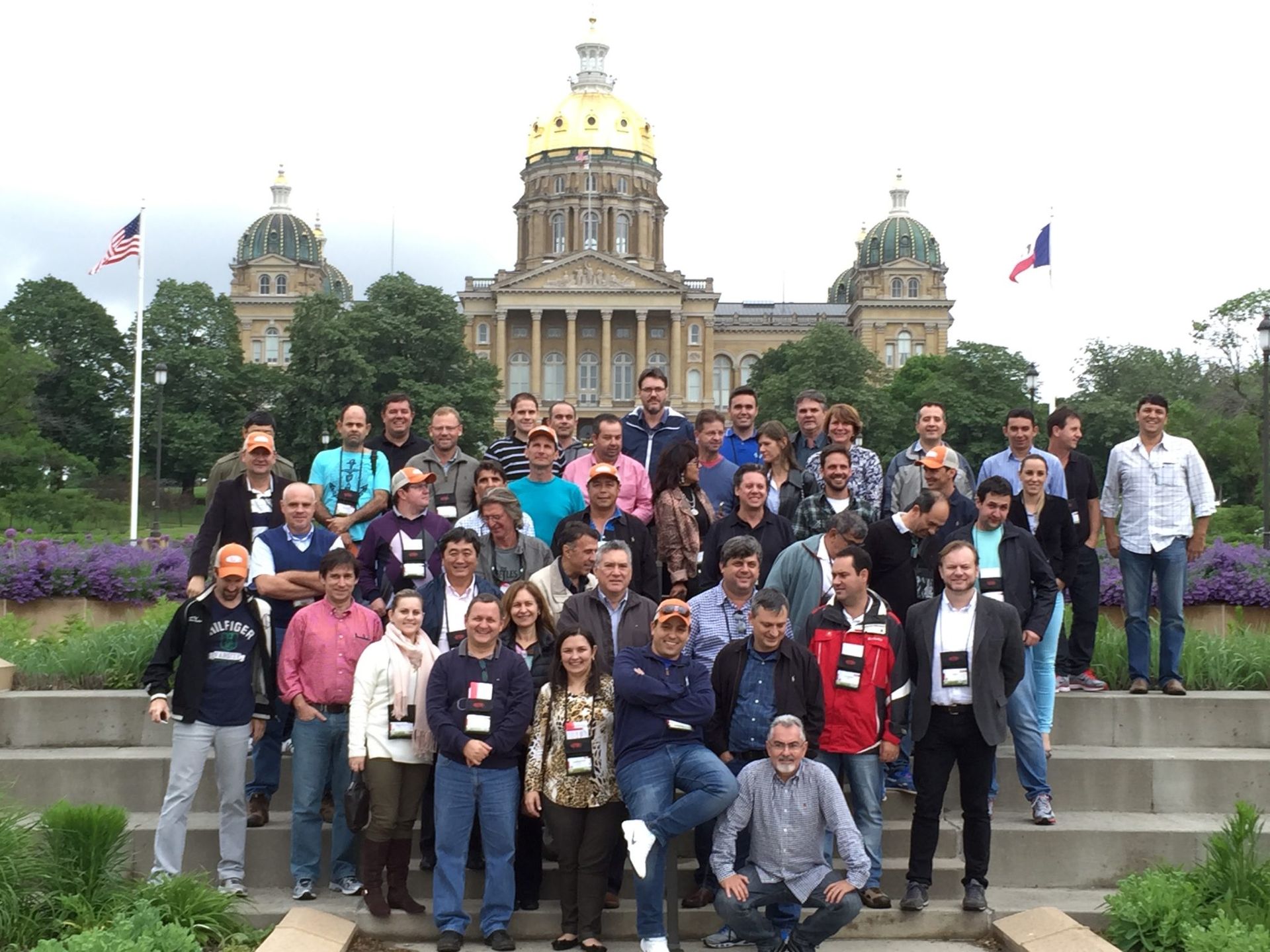 Group of people posing on steps in front of the Iowa State Capitol building. Many wearing black and white scarves.