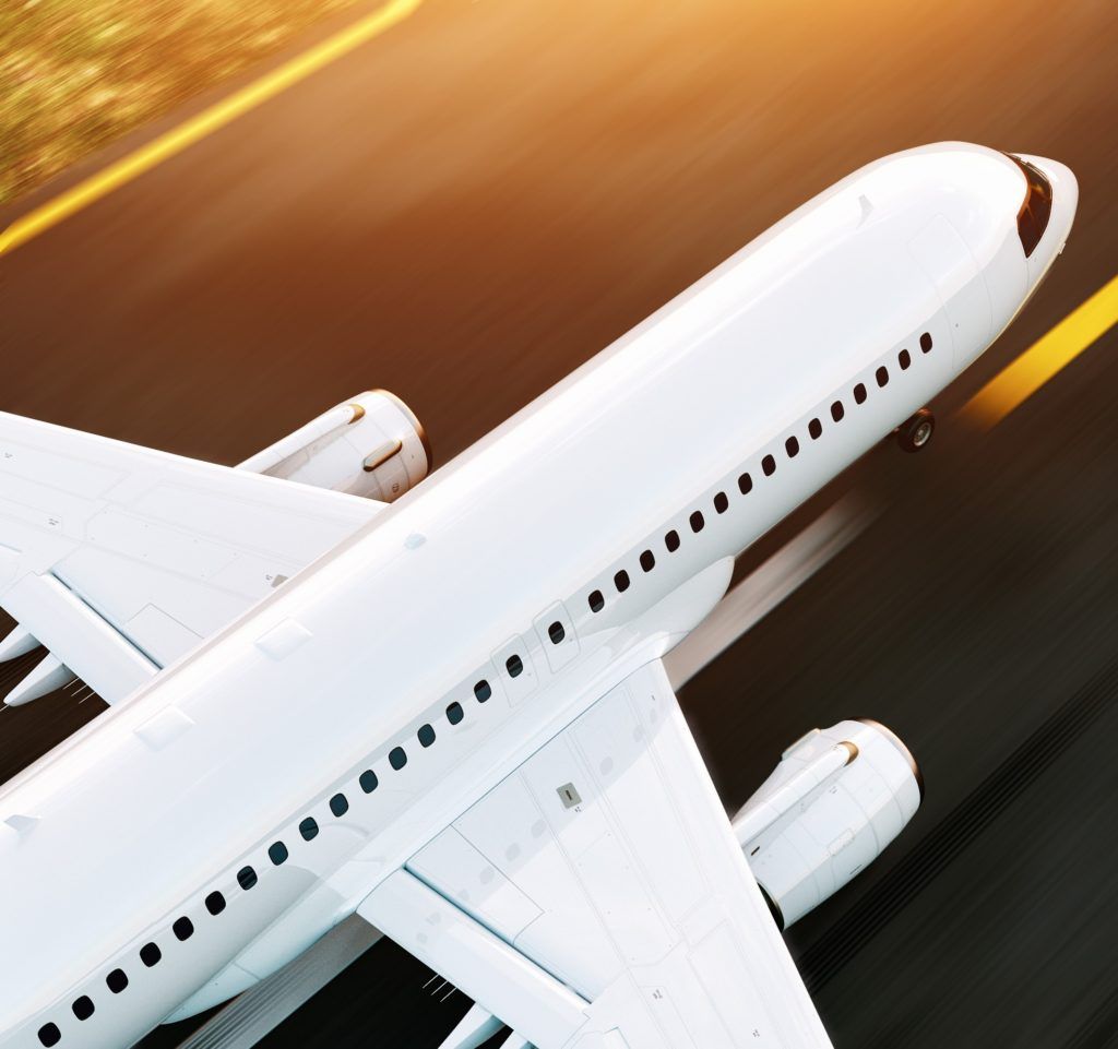White airplane taking off on a runway, yellow stripes, sunlight.