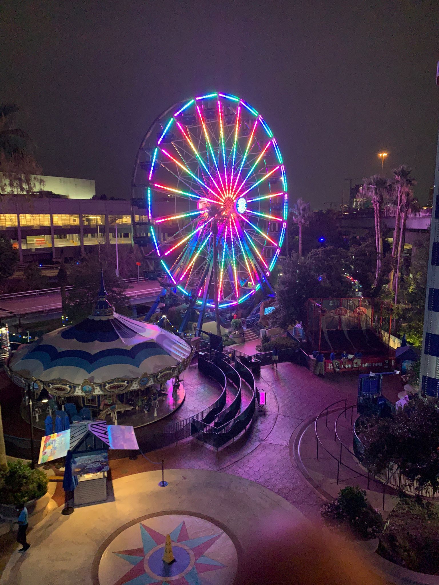 A ferris wheel is lit up at night in an amusement park
