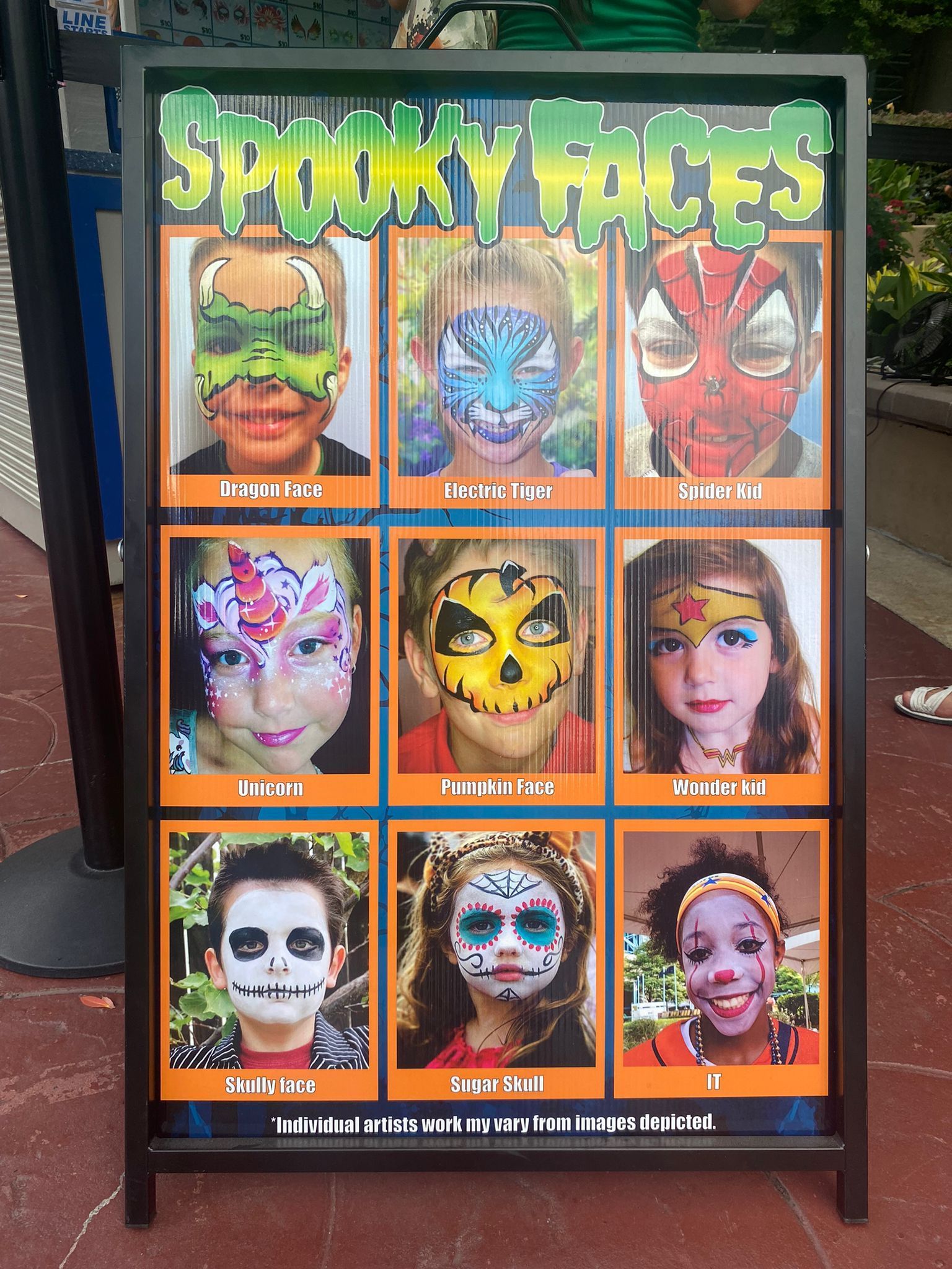 A sign that has painted faces on it