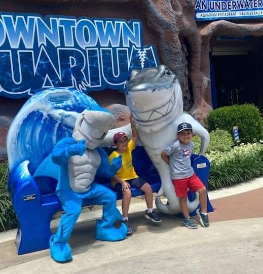 A group of children posing for a picture in front of a sign that says downtown aquarium