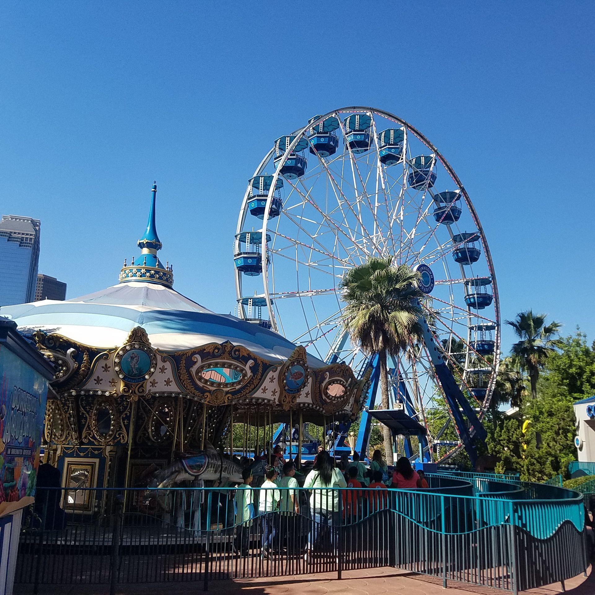 A ferris wheel with a carousel in front of it