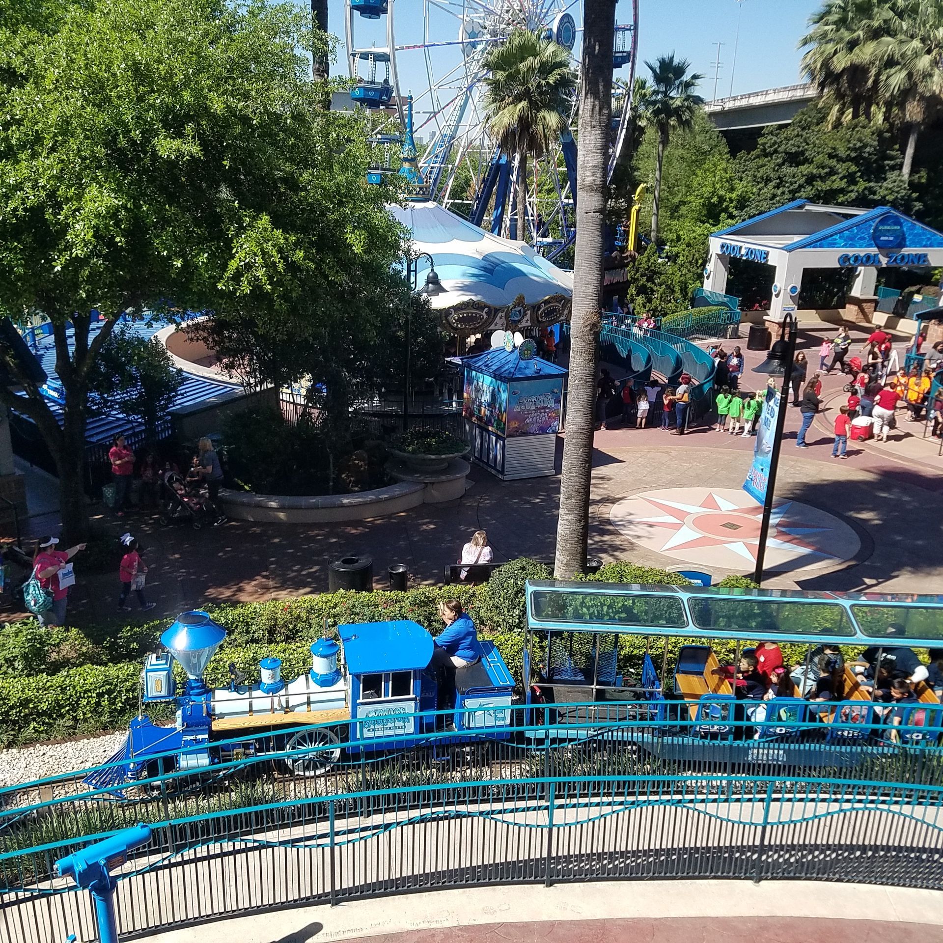 An aerial view of a blue train at an amusement park