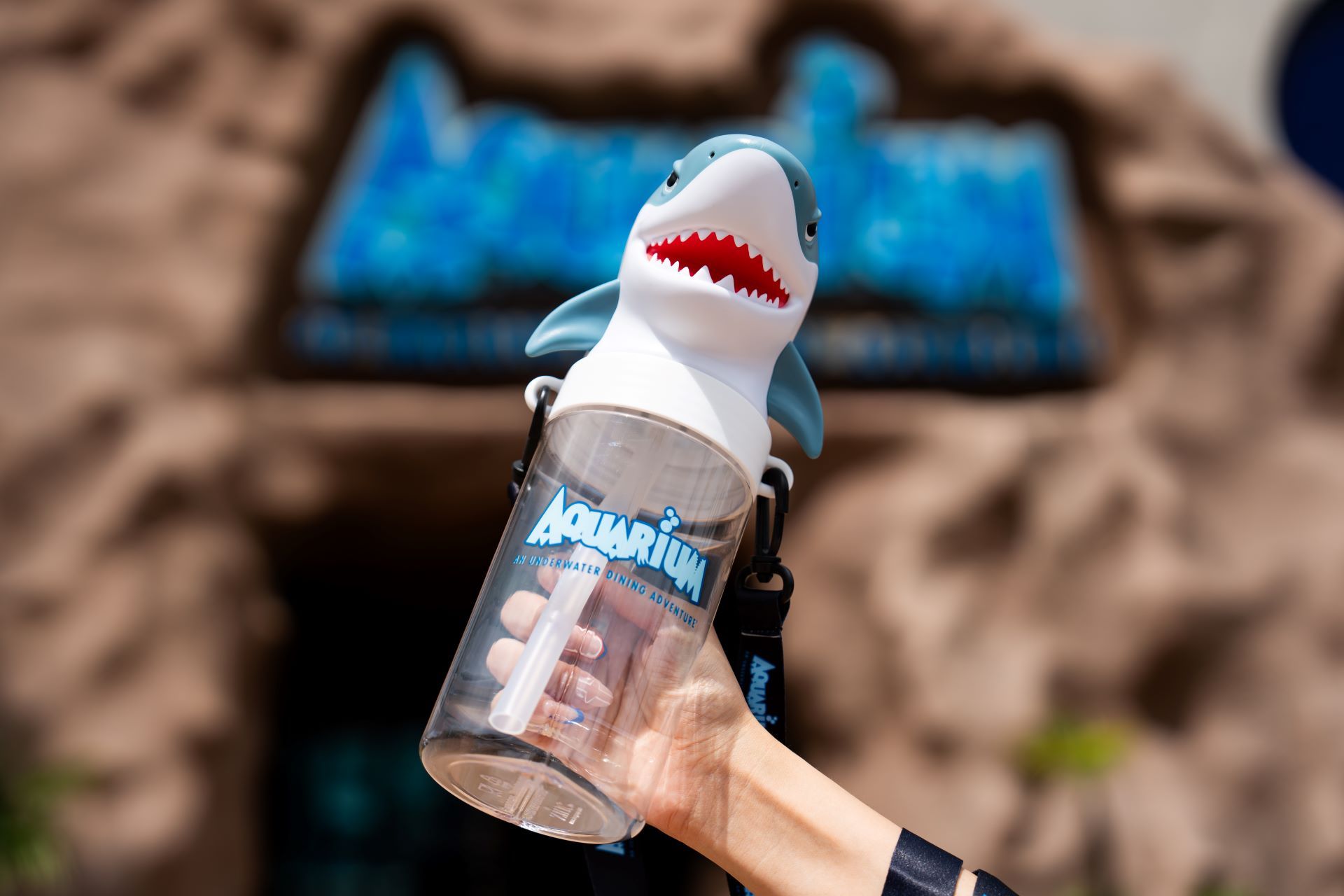 A person is holding a shark shaped water bottle